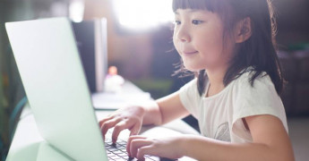 Child with laptop, typing on laptop