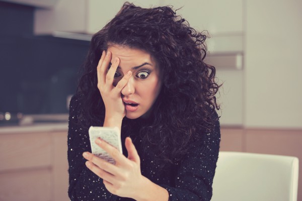 Shocked woman looking at phone, revenge porn, online safety